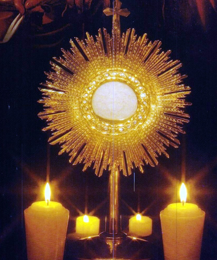 photo du Saint Sacrement exposé entouré de 4 bougies allumées